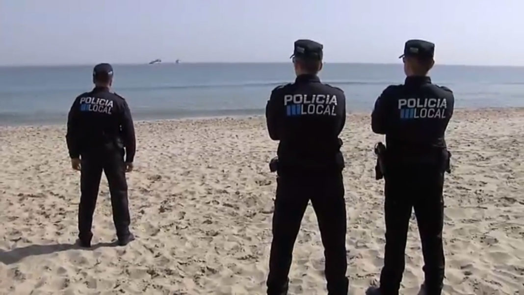 Police watching the search and rscue operation from La Manga beach