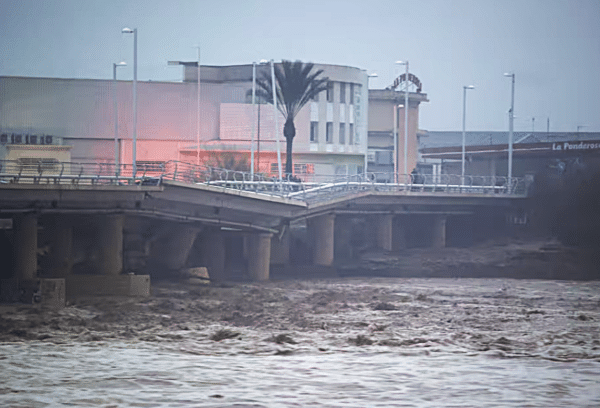 A river flows under a partially collapsed bridge affected by torrential rains that caused flooding in the town of Carlet