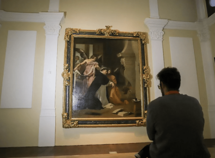 A Tourist observes 'The Temptation of Saint Thomas' at the Diocesan Museum of Sacred Art in Orihuela